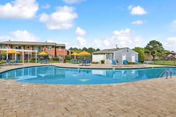 A large swimming pool surrounded by a brick patio.
